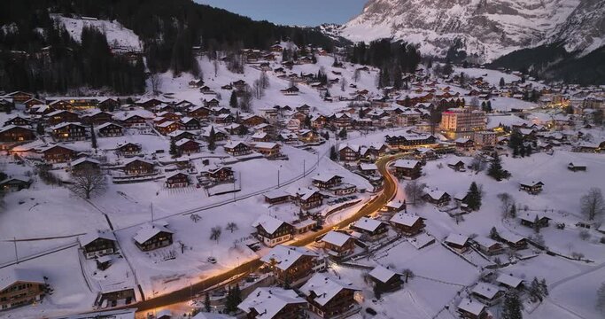 Panorama aerial Drone shot of Cottages chalets in Murren village at snowy winter night. M&uuml;rren traditional Walser mountain village in the Bernese Highlands of Switzerland. popular tourist spots.