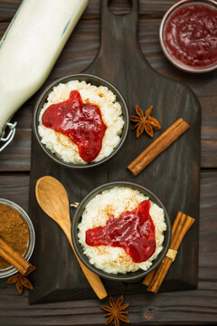 Rice pudding with cinnamon and strawberry jam on  the wooden background