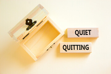 Quiet quitting symbol. Concept words Quiet quitting on wooden blocks. Beautiful white table white background. Empty wooden chest. Business and quiet quitting concept. Copy space.