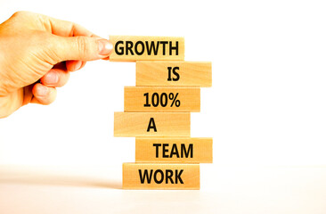 Growth symbol. Concept words Growth is 100 percent a team work on wooden blocks on a beautiful white table white background. Businessman hand. Business motivational and growth is a team work concept.