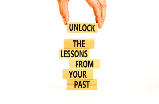 Lessons from your past symbol. Concept words Unlock the lessons from your past on wooden blocks. Bussinesman hand. Beautiful white background. Business and lessons from your past concept. Copy space.