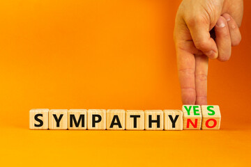 Sympathy yes or no symbol. Concept words Sympathy yes or Sympathy no on wooden cubes. Psychologist hand. Beautiful orange table orange background. Business sympathy yes or no concept. Copy space.
