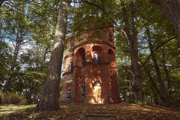 Majestic Tower built from a red bricks of Lentvaris Manor among trees with sun rays
