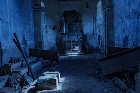 The interior of an old damaged church with moonlight