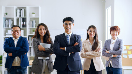 Portrait of smiling group Asian professional confident business people team standing and looking at camera © Nattakorn