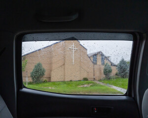 A church seen from a car window in the rain