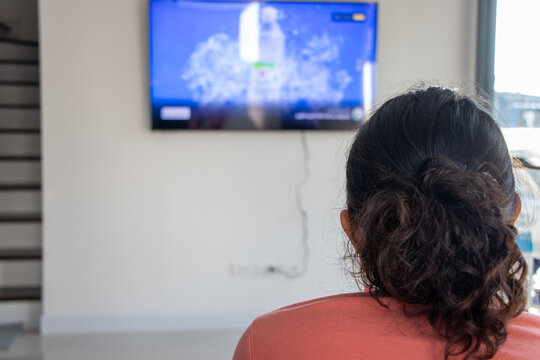 The Portrait Of Woman From Behind Watching Tv On Room Wall