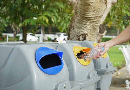 man hand discarded plastic bottle in waste sorting bin after workout.concept for outdoors exercise,plastic water bottle drinking impact,campaign recycling waste sorting to reduce global warming