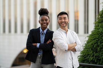 portrait business colleagues with arms crossed handsome young asian man young african american woman