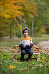 Happy family, mother with children, having their autumn pictures taken in the park