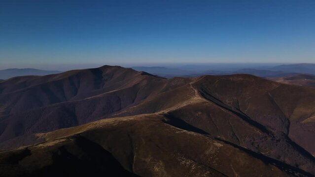 Drone flies quickly forwards over mount Gemba and mountain range in early autumn, scenic Ukrainian Carpathians landscape at sunny day