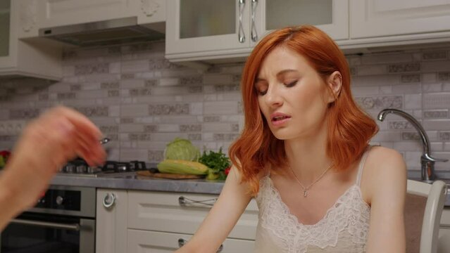 Suffering red-haired woman telling her problems to her friend. Depressed female in need of support in a friends kichen.