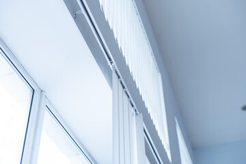 Obraz premium Large window with white roller blinds indoors