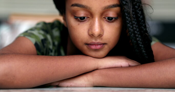 Thoughtful pensive preteen adolescent girl looking down in contemplation