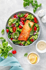 Grilled salmon fish fillet and fresh green leafy vegetable salad with tomatoes, red onion and broccoli. Healthy food. Ketogenic lunch. Top view - 533730692