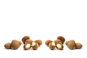 Almendras y avellanas con un baño de chocolate sobre un fondo blanco liso y aislado. Vista de frente y de cerca. Copy space