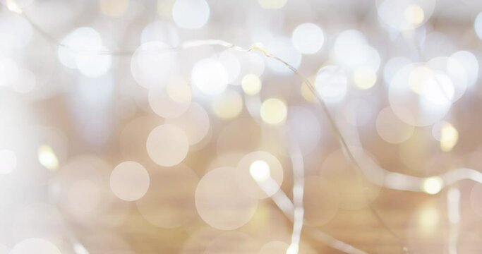 Animation of defocussed white light spots moving over glowing christmas fairy lights