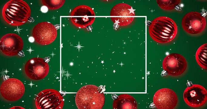 Animation of white frame with stars and snow falling over red christmas baubles on green background