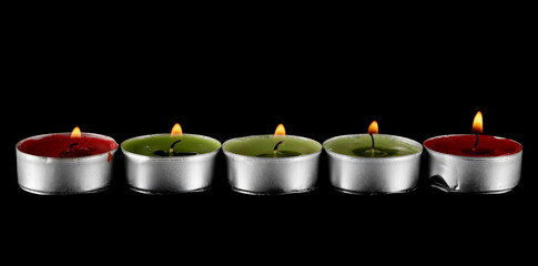 Tea light candle in holder isolated on black 