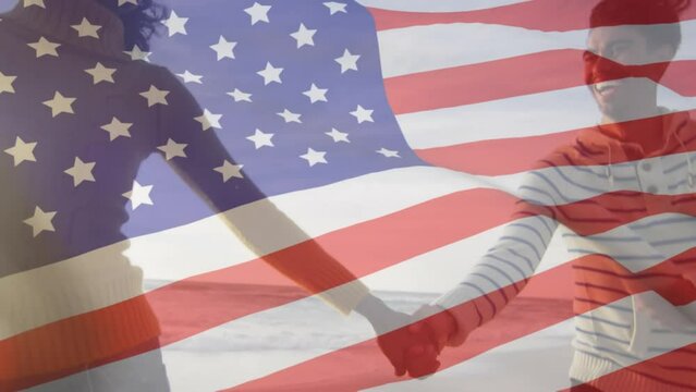 Animation of flag of united states of america over biracial couple holding hands by seaside - Powered by Adobe