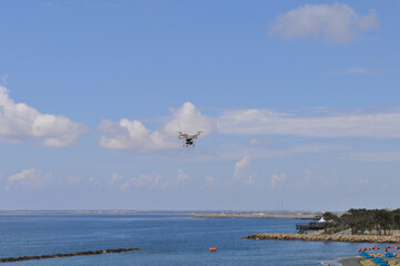 Drone with camera is flying in the nature with space in background
