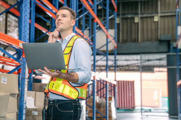 Smart smiling caucasian warehouse man,worker,manager use laptop to check goods on shelf for product distribution stock management, Logistics shipping business planning concept with copy space