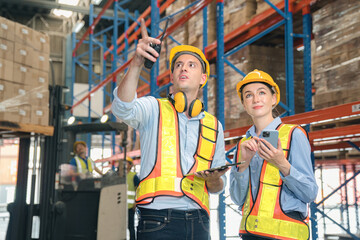 Fototapeta na wymiar Caucasian man, woman warehouse supervisor discuss and use tablet check package with forklift driver worker load box on shelf, product distribution inventory management,Logistics shipping business plan