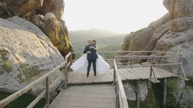 Aerial view wedding couple in mountain rock from drone in sunset landscape