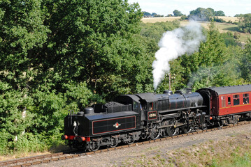 Fototapeta na wymiar Steam Locomotive and Train Approaching on Rural Heritage Railway 