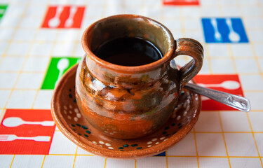 Tradicional jarro de café de olla con fondo de blanco y formas coloridas. 