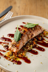 Salmon with vegetable saute. Served with fried pistachios and teriyaki sauce.