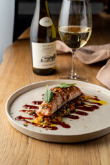 Salmon with vegetable saute. Served with fried pistachios and teriyaki sauce.