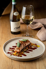 Salmon with vegetable saute. Served with fried pistachios and teriyaki sauce.