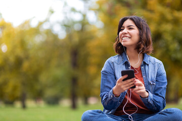 Outdoor Relax. Arab Woman Listening Music On Smartphone While Resting In Park