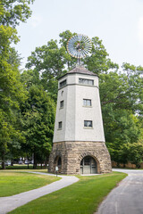 Naklejka premium Tall brick tower with wind wheel on roof