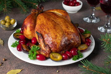 Christmas baked chicken with plum, cornelian cherries, olives and parsley on brown background