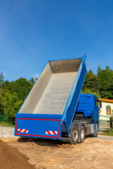 unloading the truck with potting soil from the truck bed at the construction site