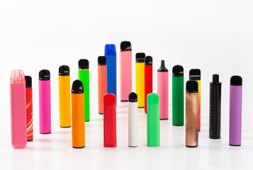 Set of colorful disposable electronic cigarettes of different shapes on a white background. The...
