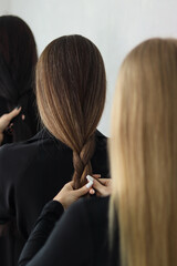 girls braiding each other's hair.braiding a kasu.braiding a kasa close-up.braiding hair.women's hair.three girls braiding each other's hair.