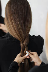 a girl braids the hair of another girl. she braids a kasu. braids kasu close-up.braids hair.girl does hairstyle.women's hair.hair close-up