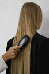 girl combing her hair.hair and comb.hairdresser.keratin hair.hair straightening.hair care.combs hair