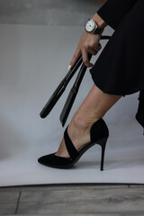 girl holding a curling iron at her leg.curling iron.black curling iron close-up.girl holding a curling iron in her hand