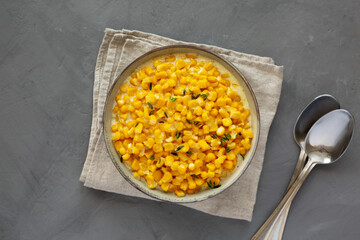 Homemade Slow Cooker Creamed Corn in a Bowl on a gray background, top view. Flat lay, overhead, from above.