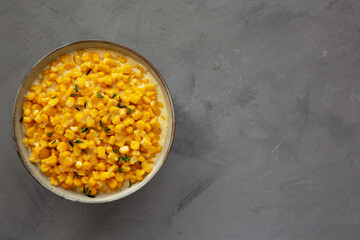 Fototapeta na wymiar Homemade Slow Cooker Creamed Corn in a Bowl on a gray background, top view. Flat lay, overhead, from above.