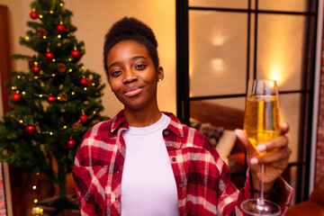 latin hispanic woman making a toast congratulations at christmas tree background
