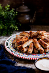 Assorted mosakhan fried roll served in a dish isolated n wooden table side view