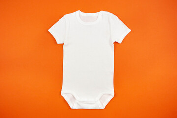 White baby girl or boy bodysuit mockup flat lay on orange background. Design onesie template, print...