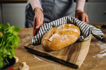 woman holding fresh home made baked bread in her kitchen