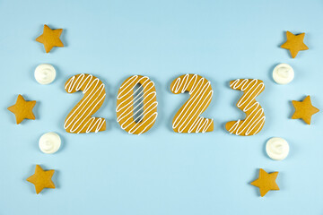 Gingerbread cookie in shape of 2023 number on blue background. Merry Christmas and Happy New Year.