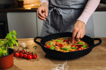 woman prepares home made pizza in kitchen